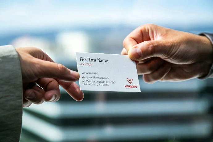 Two hands exchanging a business card
